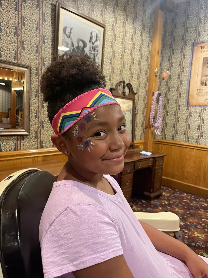 girl with facial makeup and headband